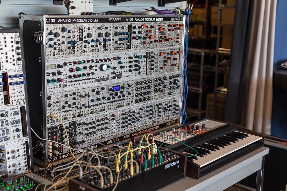Doepfer A-100 Eurorack modular system with a Roland sequencer wired with many patch cables and a keyboard in front