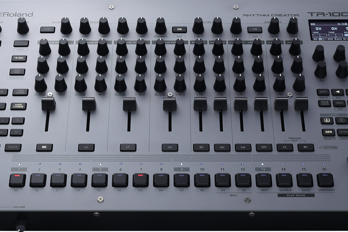 Roland TR-1000 drum machine at a three-quarter angle: grey panel, rows of black knobs, faders, sixteen step keys and display